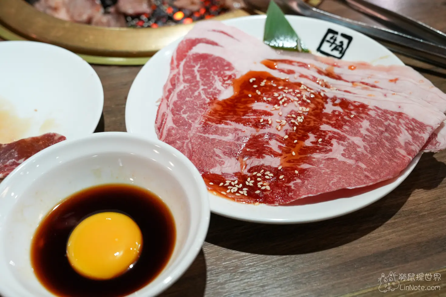 薄切肉片盤旁搭配一碗生蛋黃沾醬