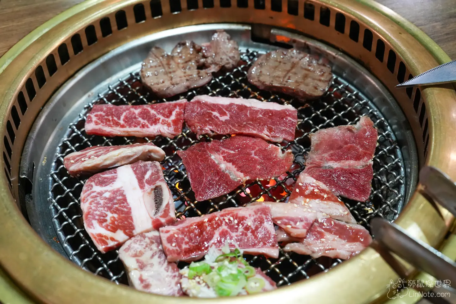 烤肉爐網上鋪排著生牛肉片與烤熟的薄切牛舌