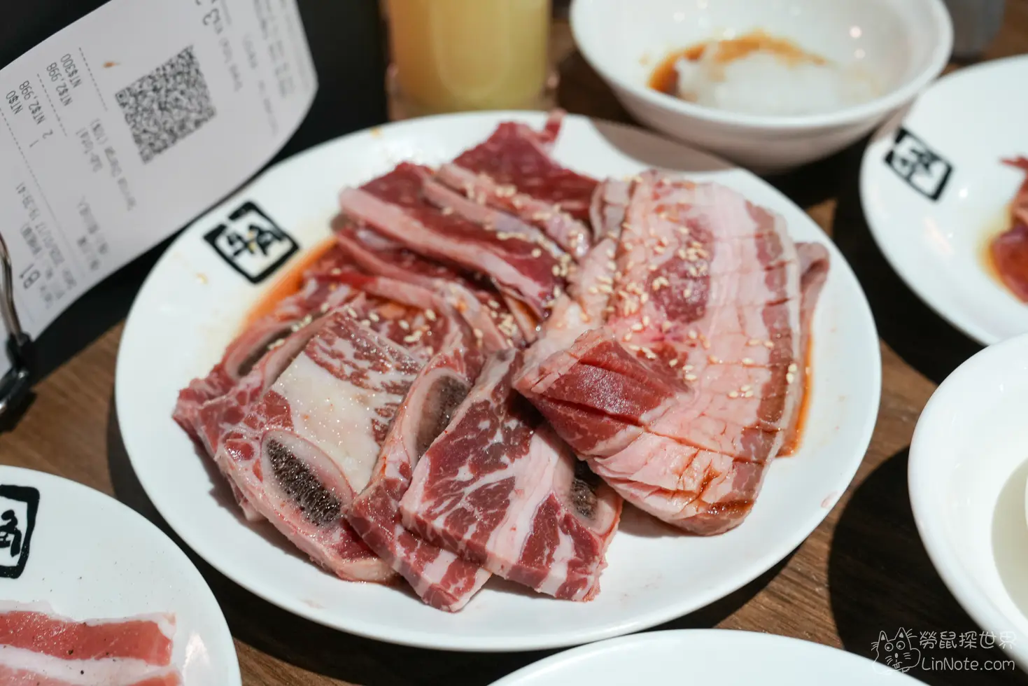 盛裝在白盤中的帶骨牛小排與薄切牛肉切片