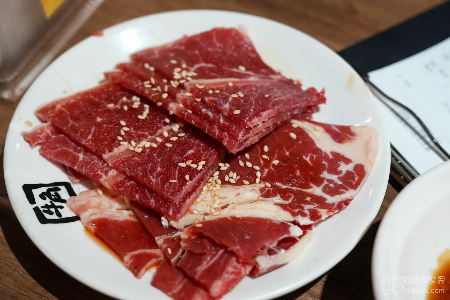 整齊疊放撒有白芝麻的鮮紅色牛小排生肉切片