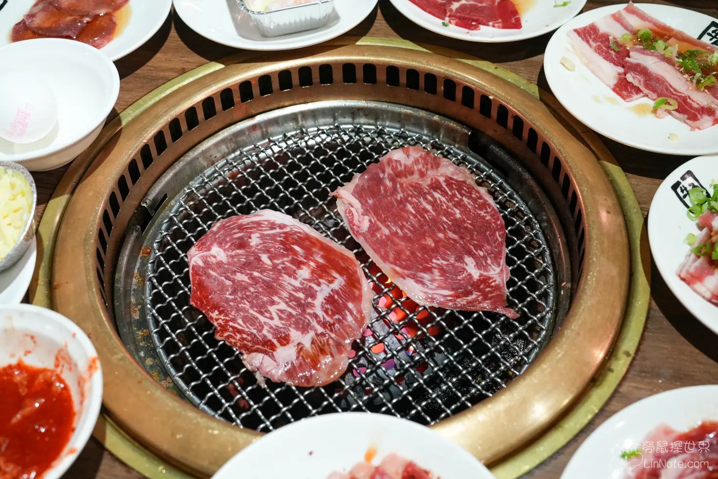 金屬烤網上炙烤著兩大片油花均勻的生牛肉片