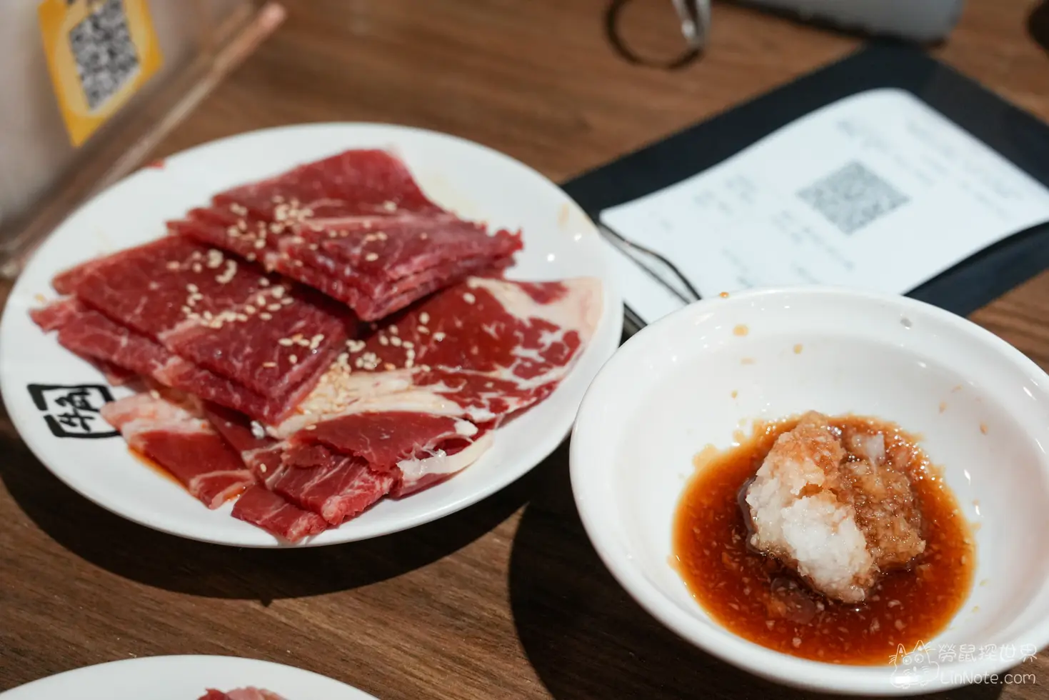 生牛肉肉盤旁附上一碗盛裝蘿蔔泥與醬汁的沾醬