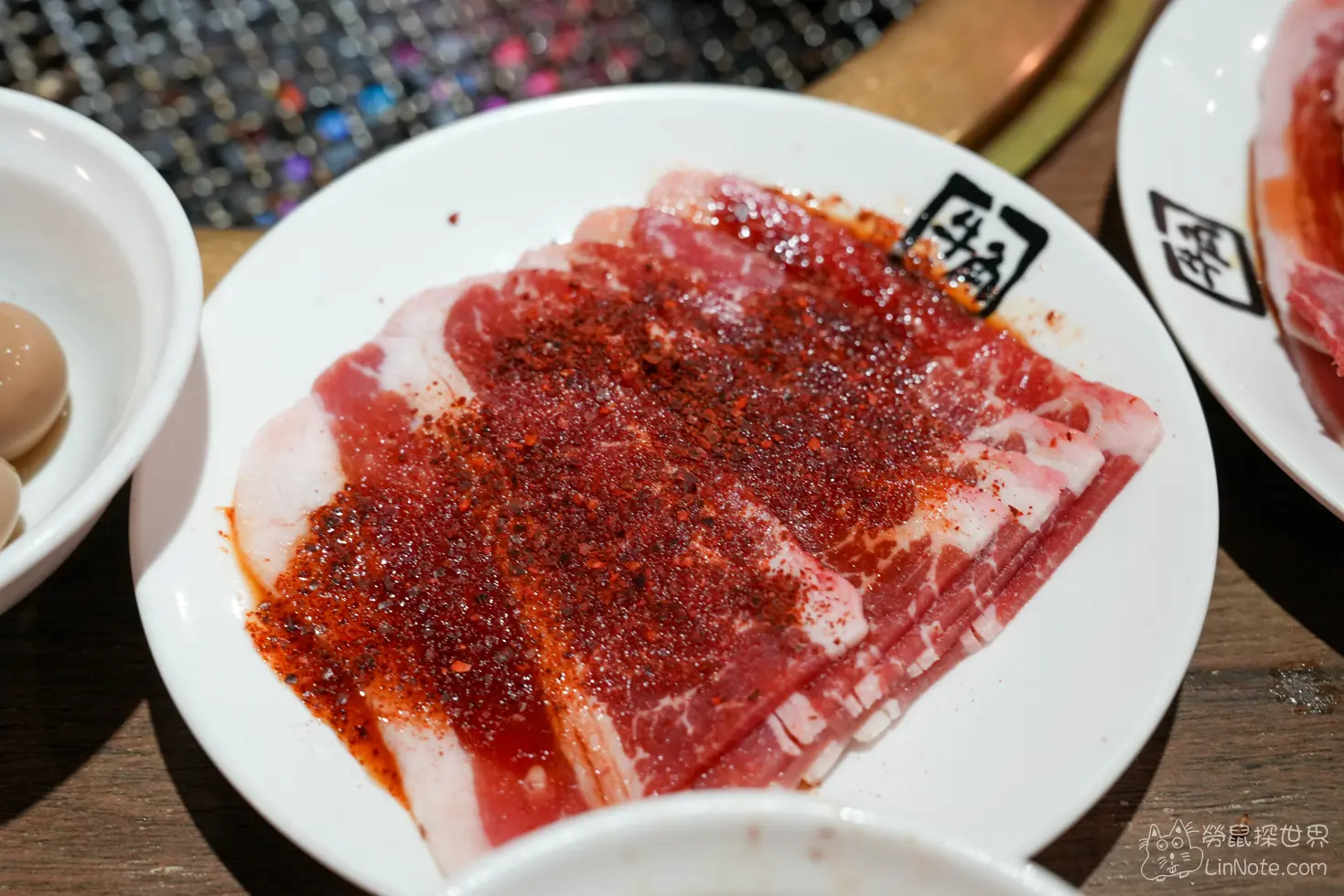 盤中疊放撒滿深紅色辣椒調味粉的生肉切片