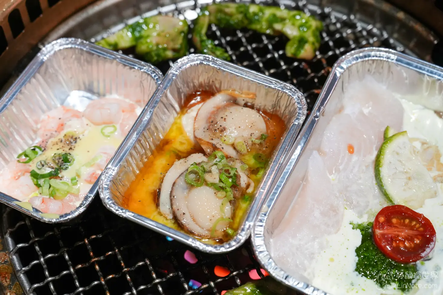 烤網上整齊排列盛裝蝦仁調味扇貝與魚片的鋁箔盒