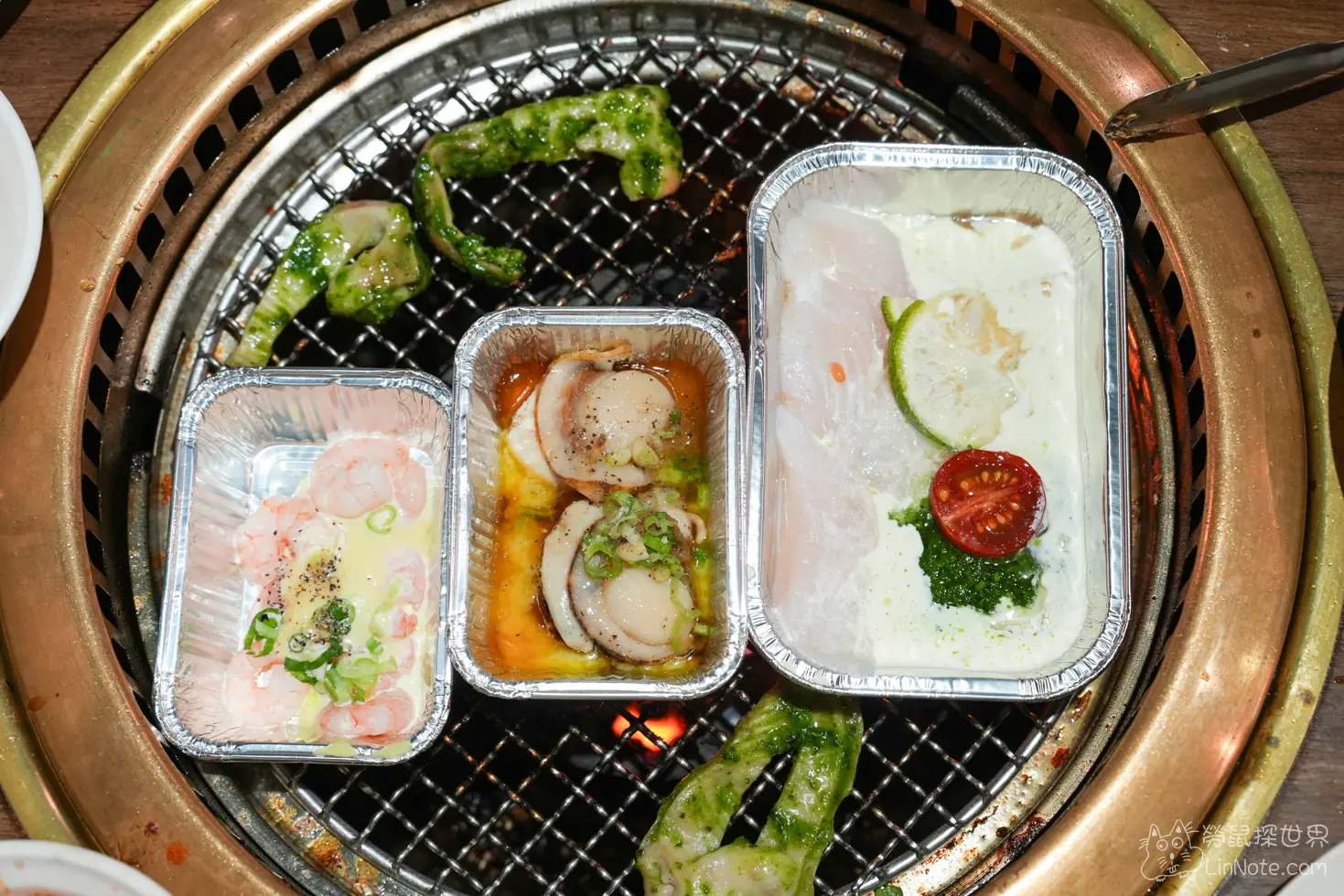 烤網上同時加熱三盒不同海鮮鋁箔盒與青醬肉品