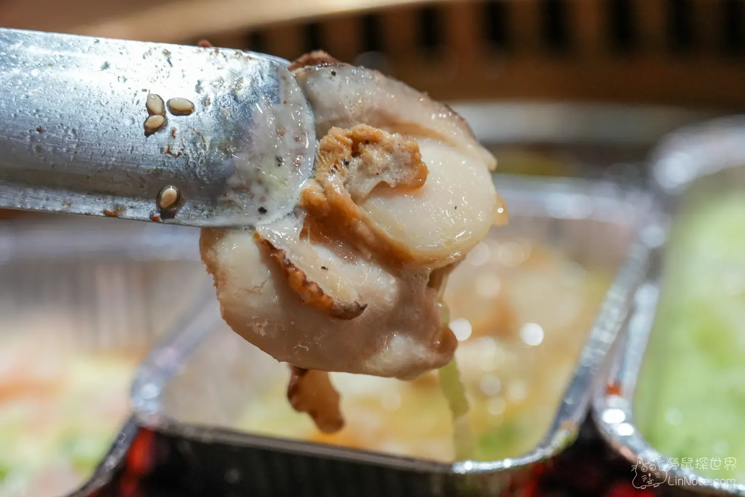 金屬夾子夾起一顆帶有干貝唇的肥厚貝類食材