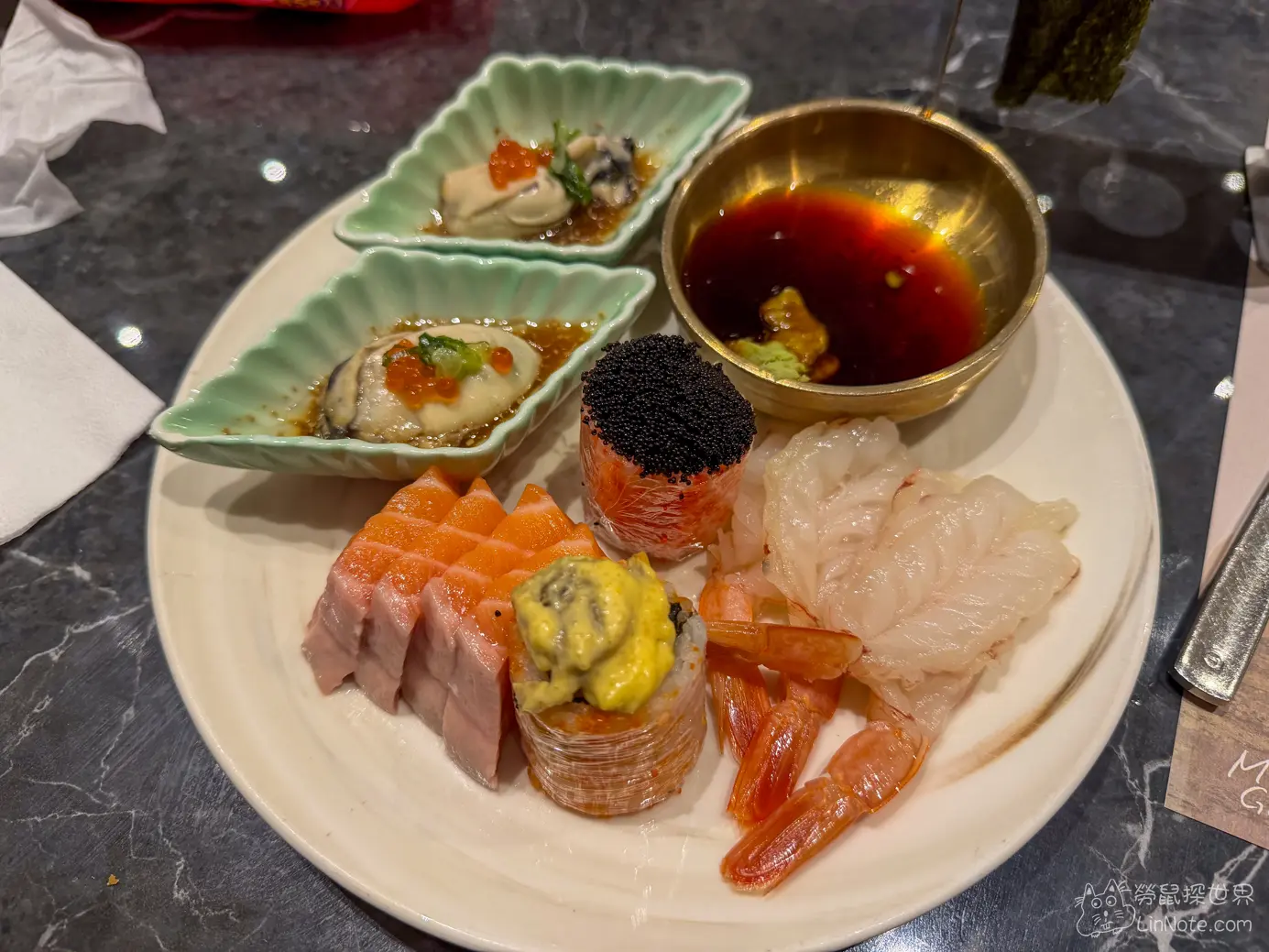 餐盤盛裝的鮭魚生魚片甜蝦與生蠔佐鮭魚卵