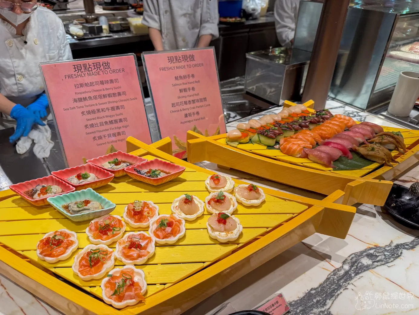 日料餐檯上擺放的花型鮭魚小點與各式精緻握壽司