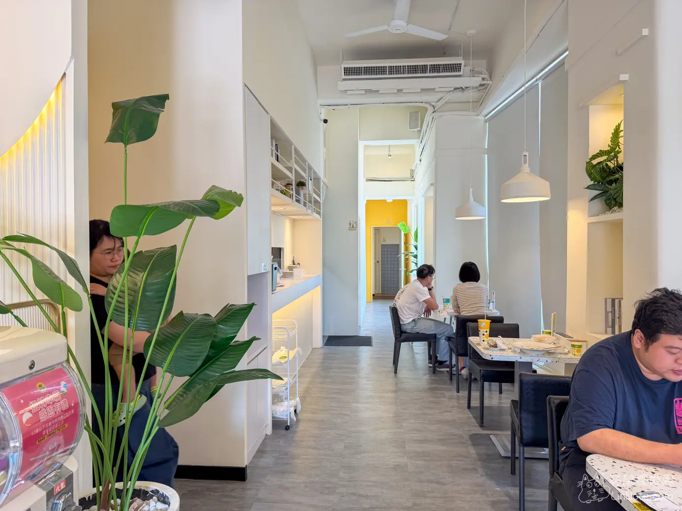 餐廳內部狹長明亮的純白簡約走道與用餐區