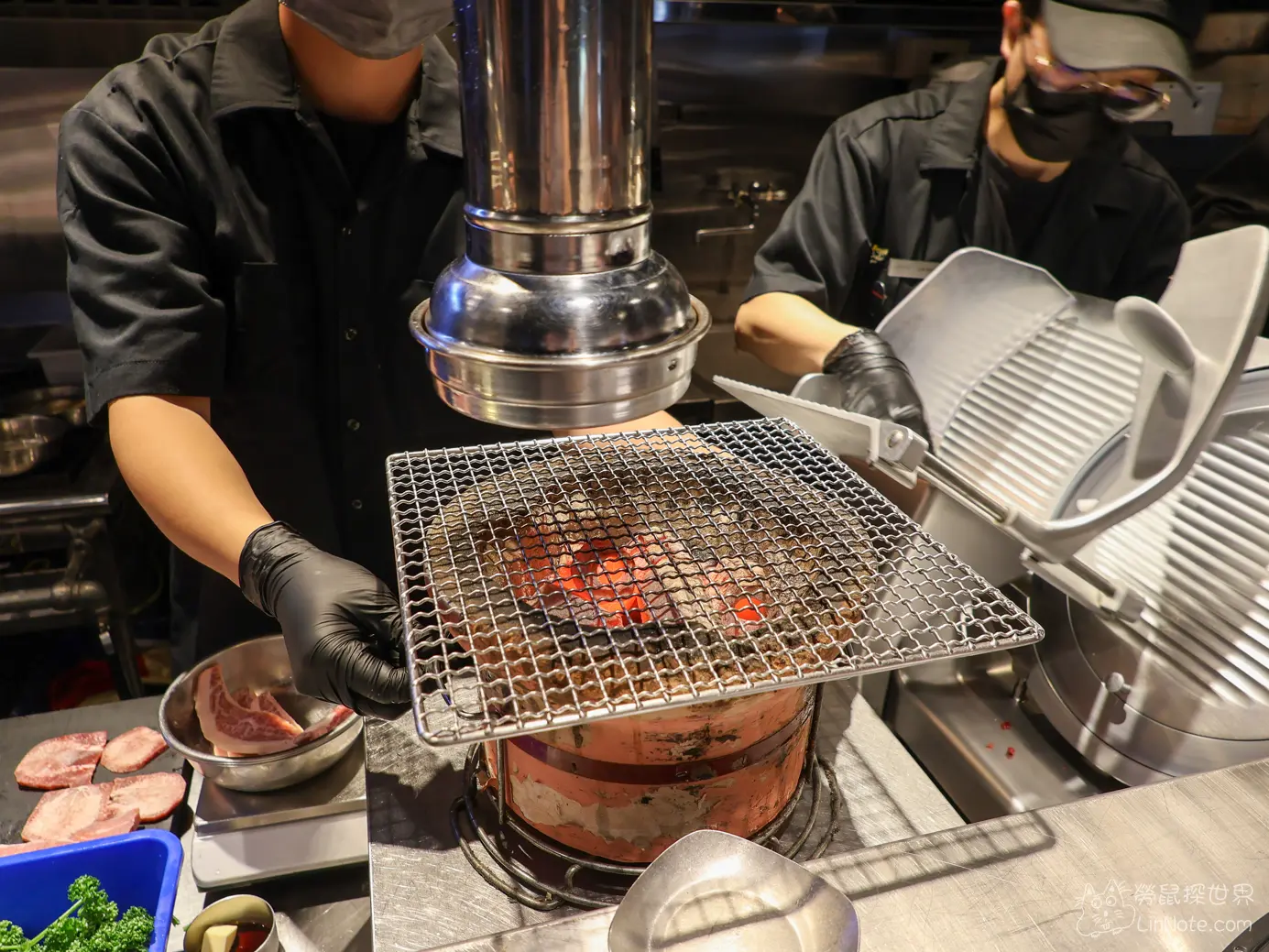燒肉店吧檯內炭火爐架著烤網與店員專注操作切肉機