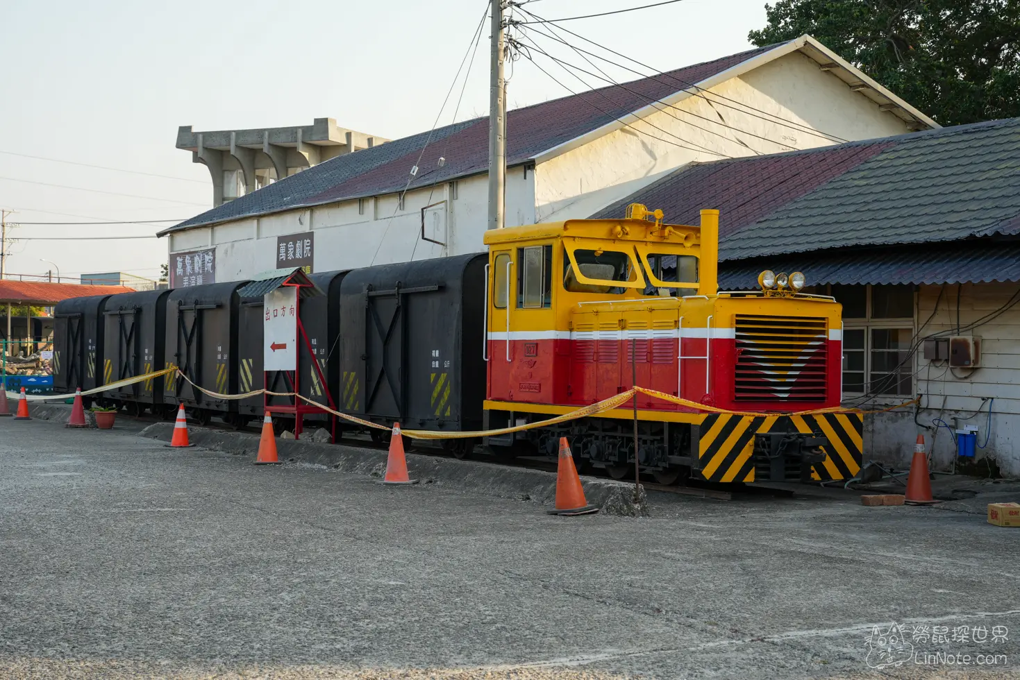 戶外空地上由黃紅塗裝車頭牽引的黑色展示車廂