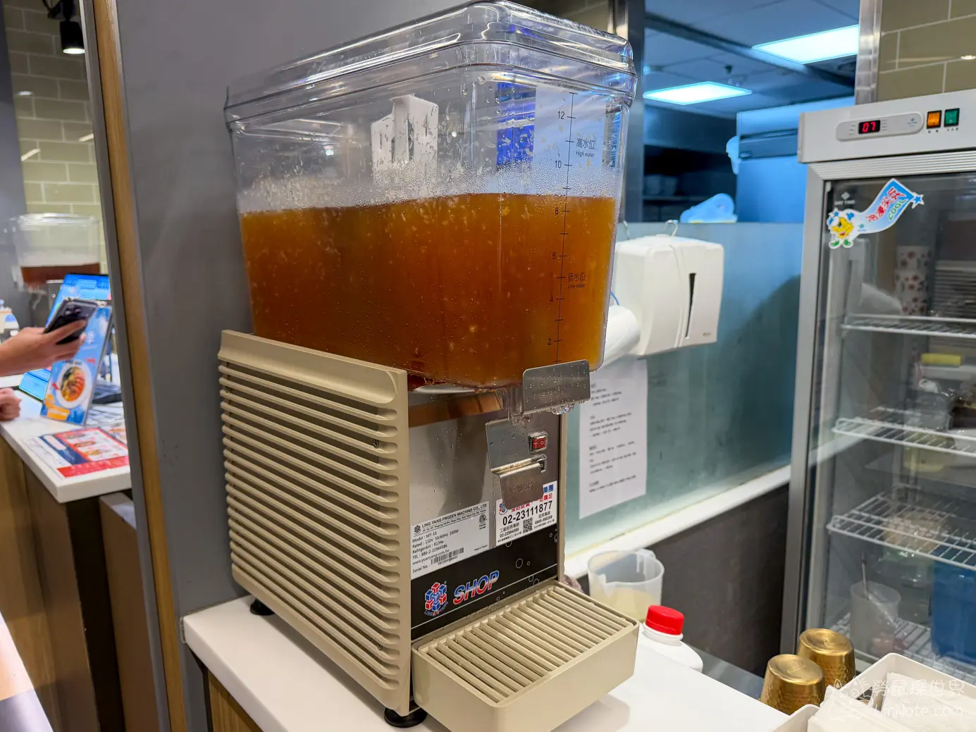 吧檯上的冬瓜檸檬冷飲機與冷藏展示櫃