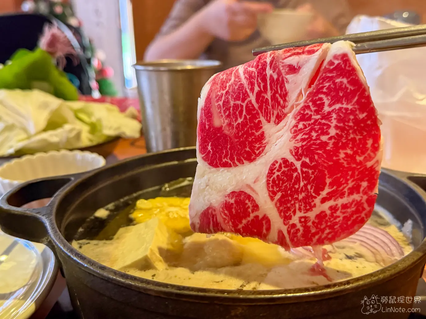 筷子夾起大片油花細緻的牛肉懸在沸騰的火鍋上方