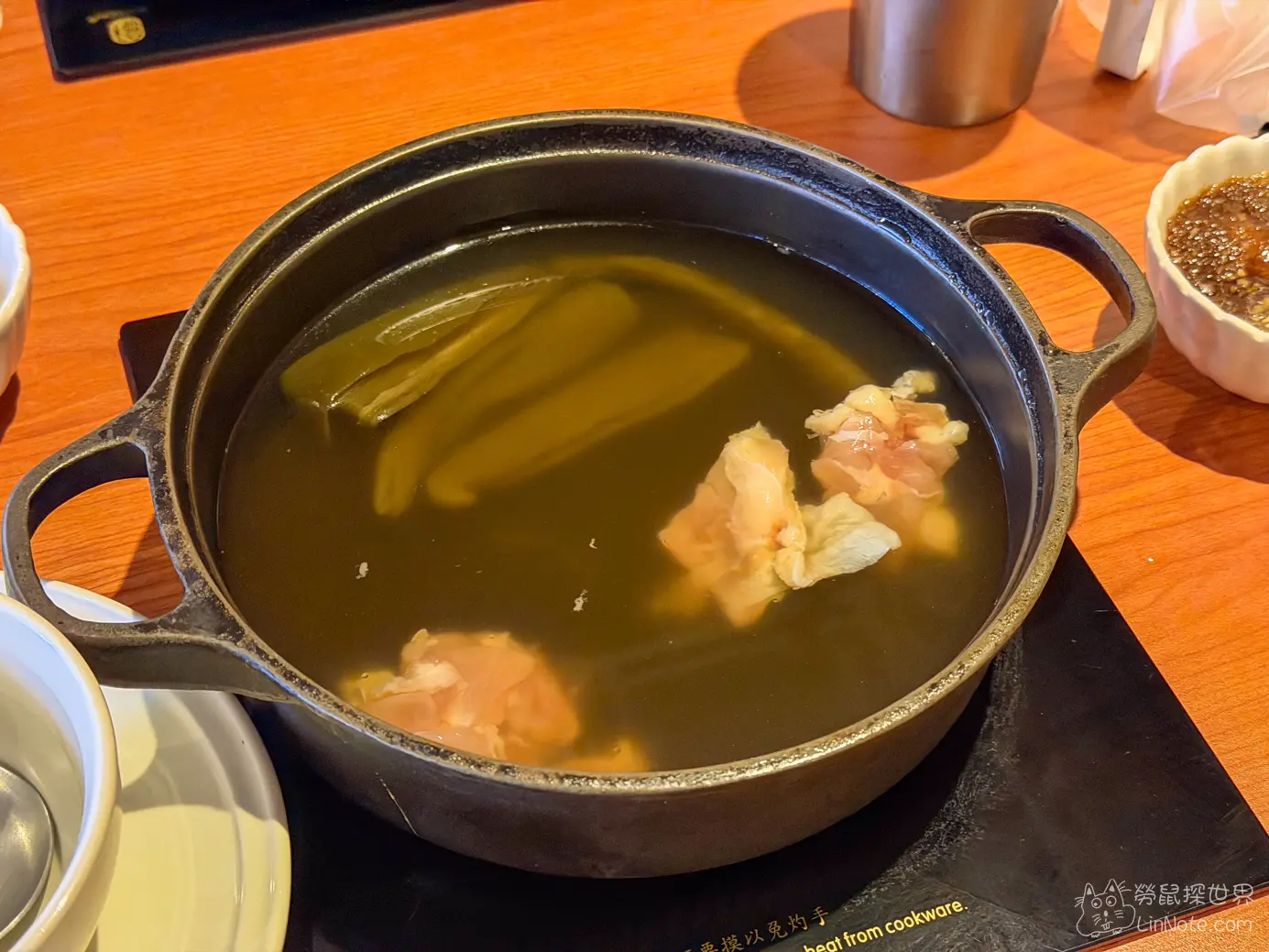 黑色鐵鍋內的剝皮辣椒雞湯底與雞肉塊