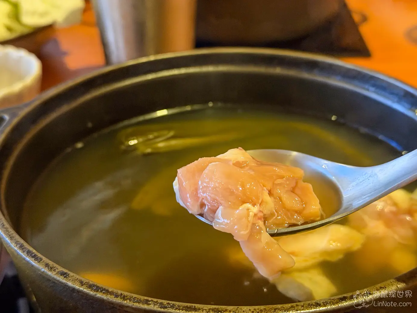 湯匙舀起花蓮剝皮辣椒雞湯鍋內飽滿鮮嫩的雞肉塊