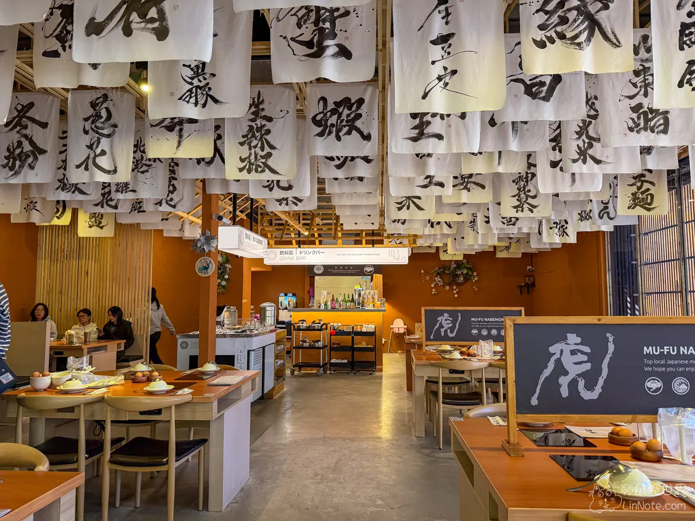 沐府火鍋中央走道與兩側寬敞的木質餐桌隔板座位區