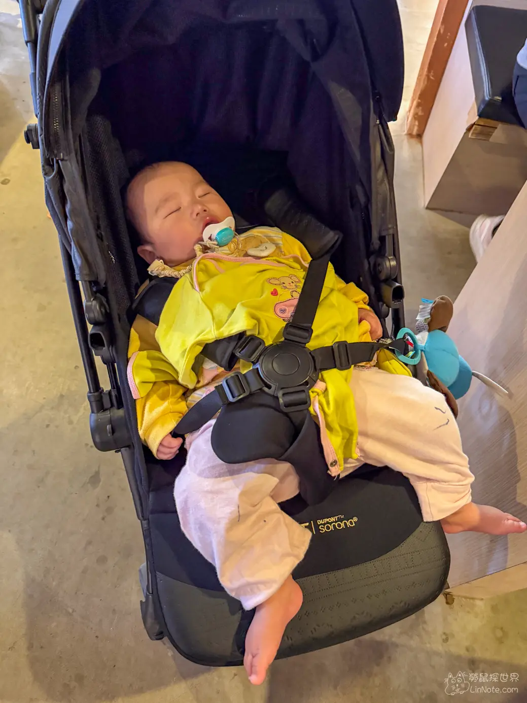 推車停放在寬敞走道旁熟睡的嬰兒