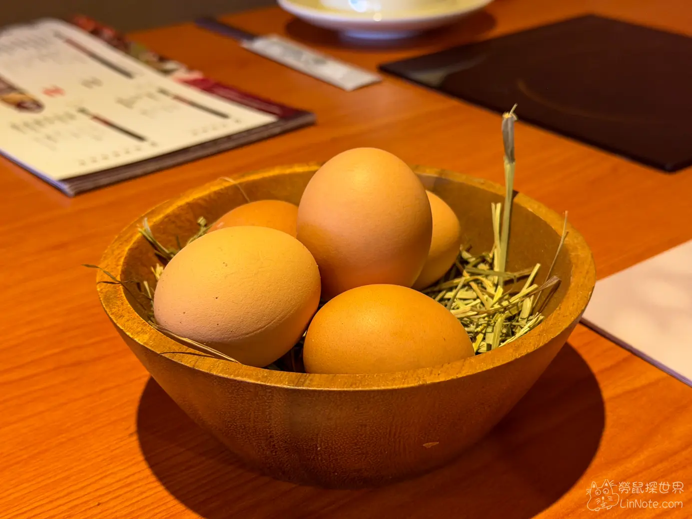 木質圓碗內鋪著稻草盛裝的生雞蛋