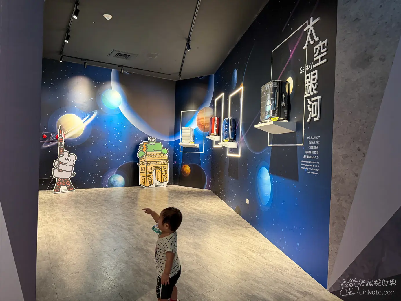太空銀河主題展區深藍色星空壁畫與發光行李箱展示