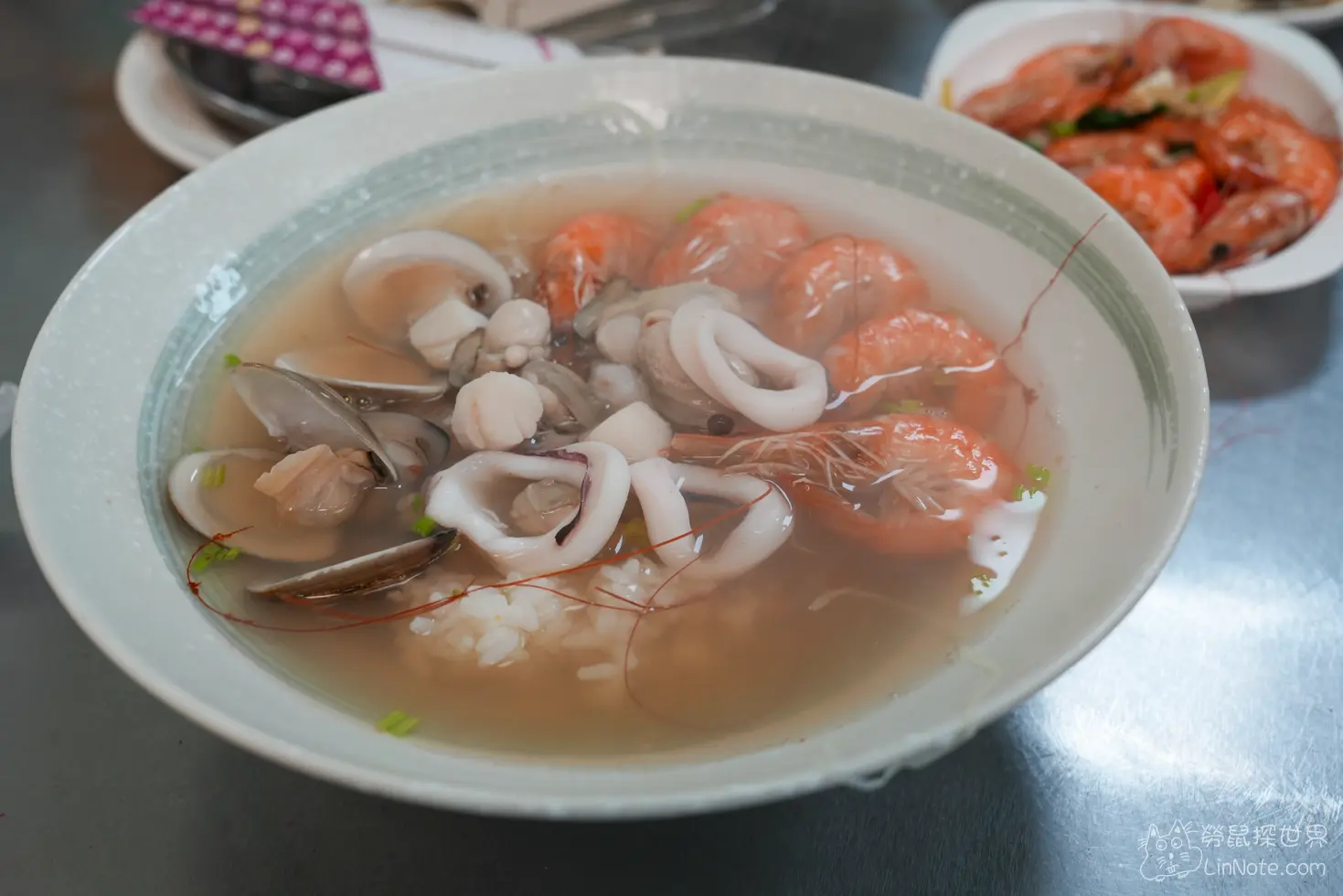 招牌海產粥盛裝著清湯、白飯、鮮蝦與多種海鮮配料