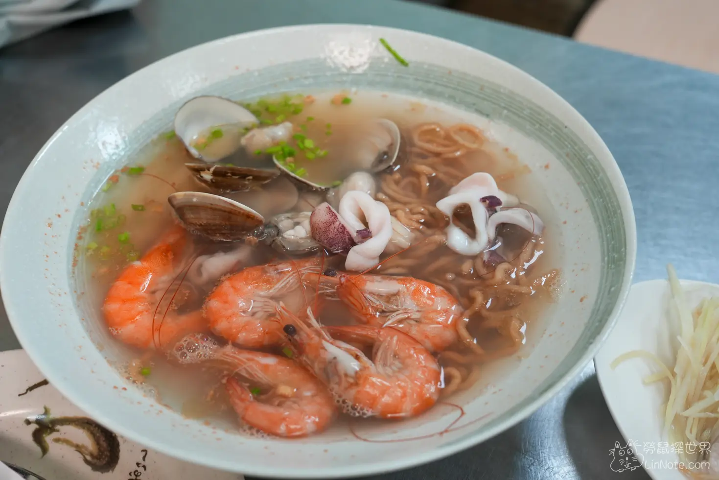 招牌海產意麵碗內鋪滿了鮮蝦、花枝與清甜湯頭