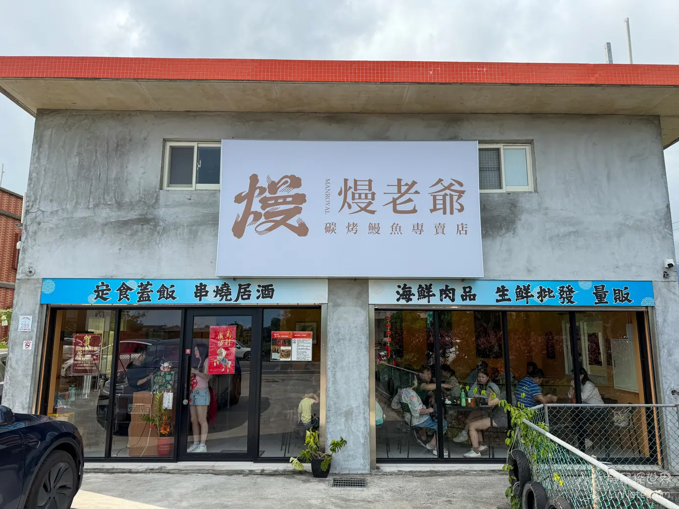 宜蘭礁溪熳老爺碳烤鰻魚專賣店的水泥外觀與門口落地窗